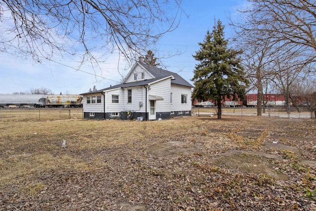 back of property featuring cooling unit and fence