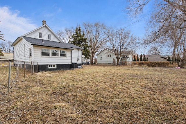 back of property featuring roof with shingles, a yard, a chimney, central air condition unit, and fence