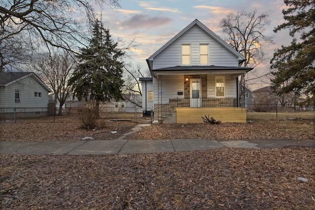 bungalow with covered porch and a fenced front yard