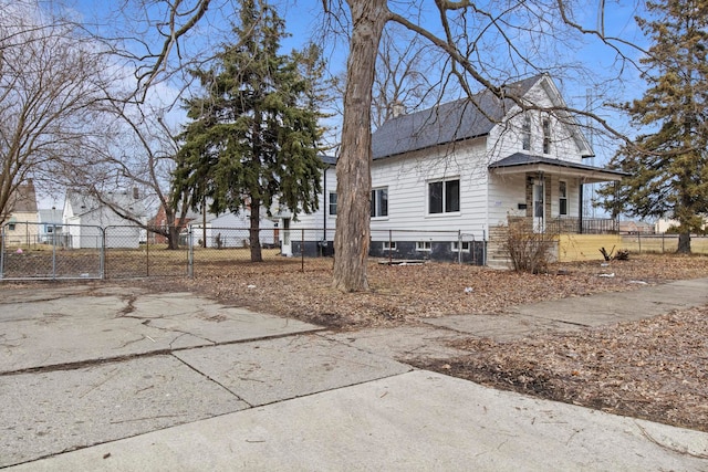 view of property exterior featuring a fenced front yard and a gate