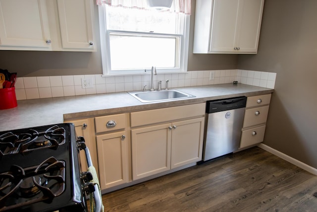 kitchen with dark wood-style flooring, range with gas cooktop, light countertops, a sink, and dishwasher