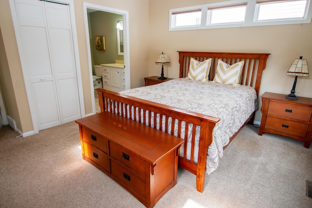 carpeted bedroom with a closet, visible vents, connected bathroom, and baseboards