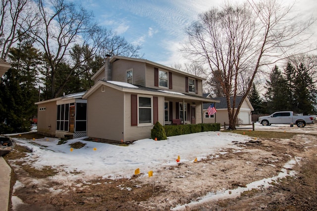 traditional-style home with a sunroom, an outdoor structure, and a chimney