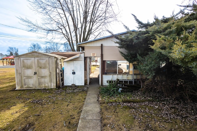 rear view of property featuring a shed and an outbuilding