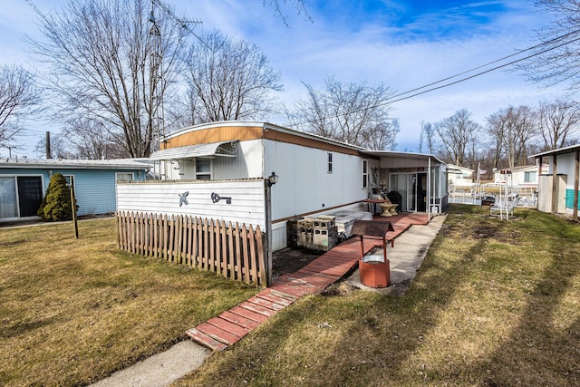 exterior space with fence and a lawn