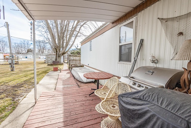 wooden terrace with a yard and grilling area