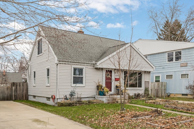 view of front of house with roof with shingles, fence, and a chimney