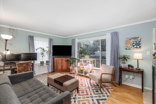 living area with ornamental molding, baseboards, and wood finished floors