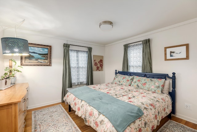 bedroom with wood finished floors and baseboards