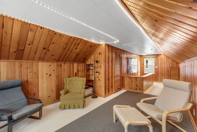 sitting room with lofted ceiling, wood walls, and carpet