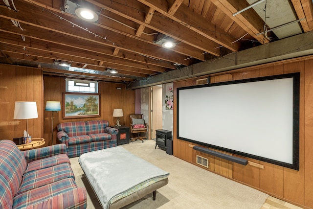 home theater featuring carpet floors, wood walls, and visible vents