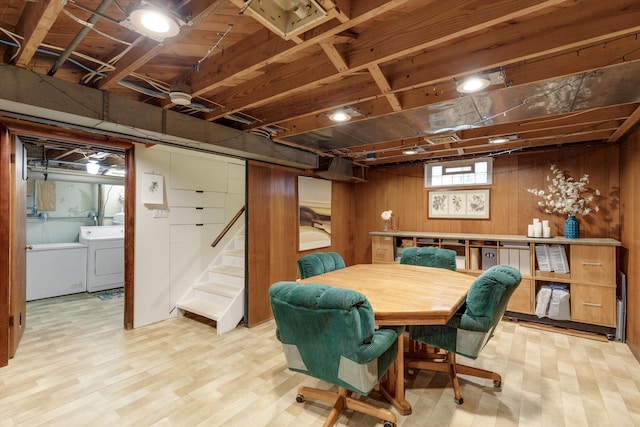 dining space featuring wooden walls, washing machine and dryer, stairway, and wood finished floors