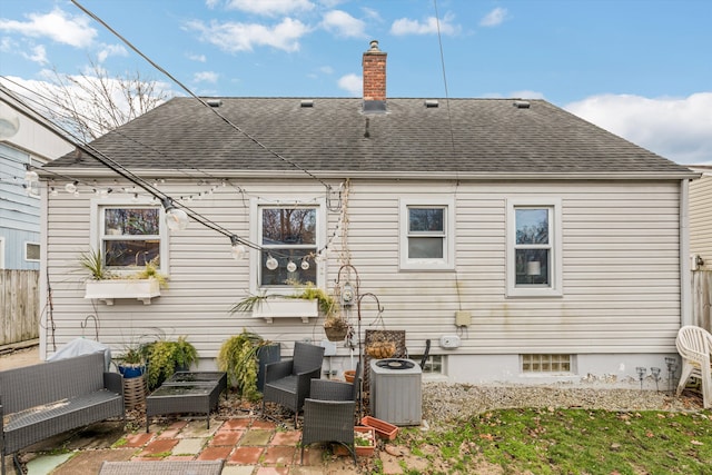 back of house featuring a patio, a shingled roof, an outdoor living space, and central air condition unit