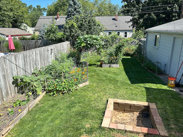 view of yard featuring fence and a vegetable garden