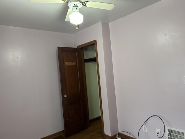 unfurnished bedroom featuring baseboards, visible vents, dark wood finished floors, and a ceiling fan