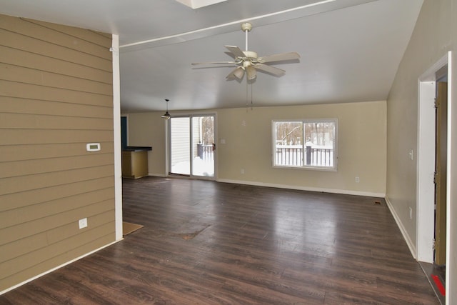 unfurnished living room featuring vaulted ceiling, dark wood-type flooring, a ceiling fan, and baseboards