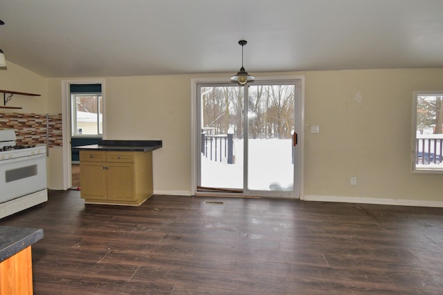 kitchen featuring baseboards, decorative backsplash, dark countertops, dark wood-style flooring, and gas range gas stove