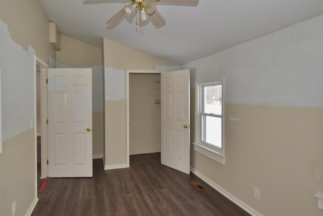 unfurnished bedroom with wood finished floors, visible vents, baseboards, vaulted ceiling, and a closet