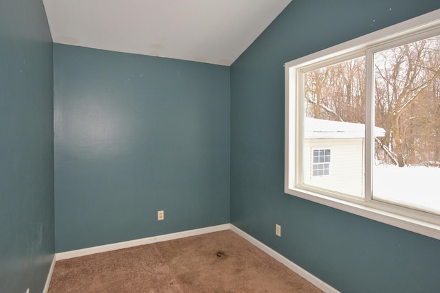 unfurnished room featuring carpet floors, baseboards, and lofted ceiling