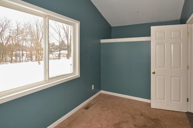 unfurnished bedroom with baseboards, visible vents, vaulted ceiling, and carpet flooring