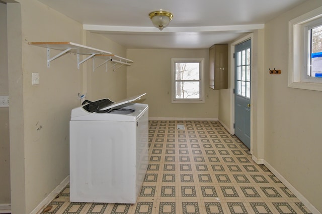 clothes washing area with light floors, laundry area, and baseboards