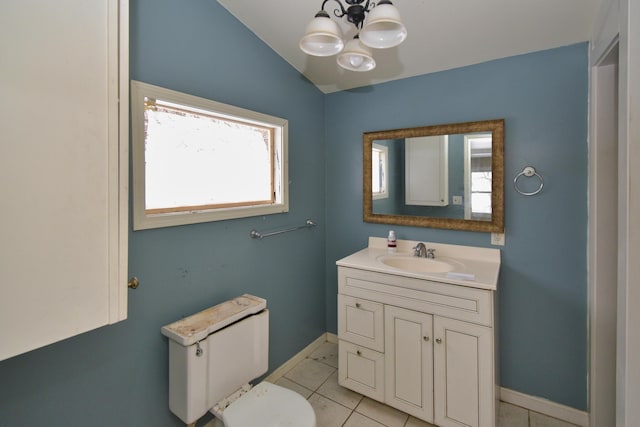 bathroom with baseboards, lofted ceiling, tile patterned floors, vanity, and a chandelier