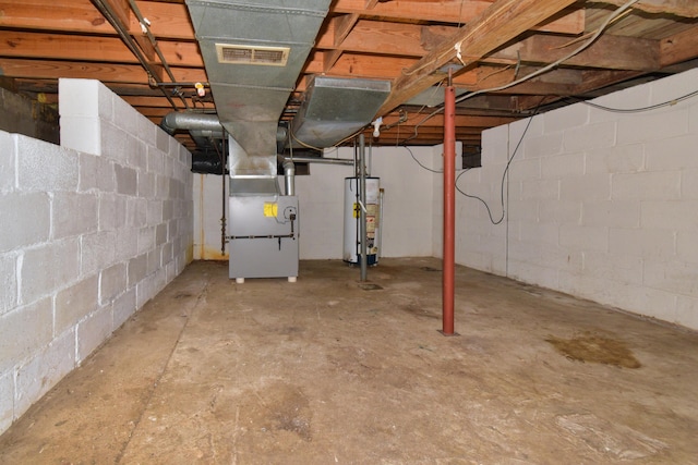 unfinished below grade area featuring visible vents, heating unit, and water heater