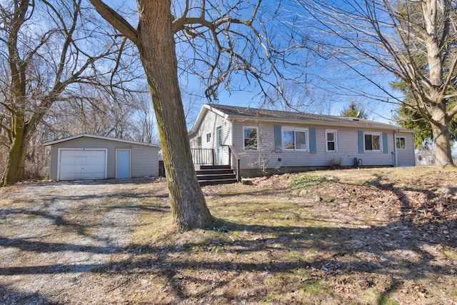 ranch-style home featuring a garage, an outbuilding, and driveway