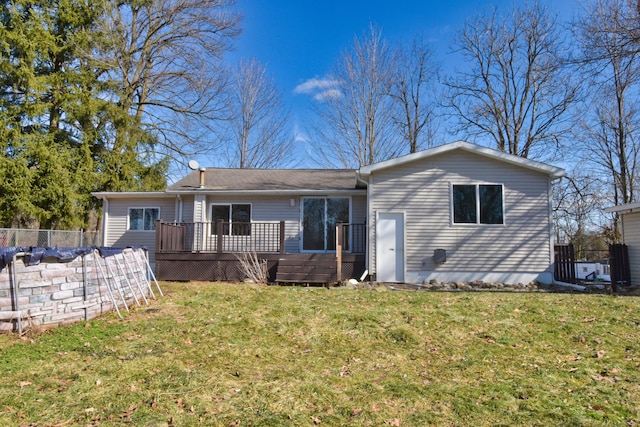 back of property featuring a wooden deck, fence, and a yard