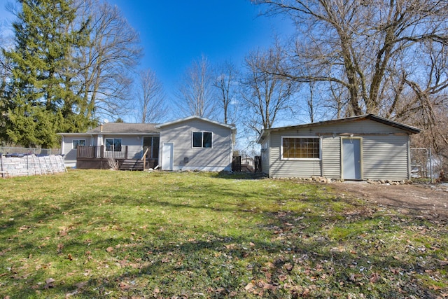 rear view of house with an outbuilding, fence, a deck, and a yard