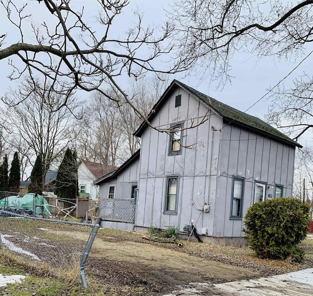 view of side of property featuring board and batten siding and fence