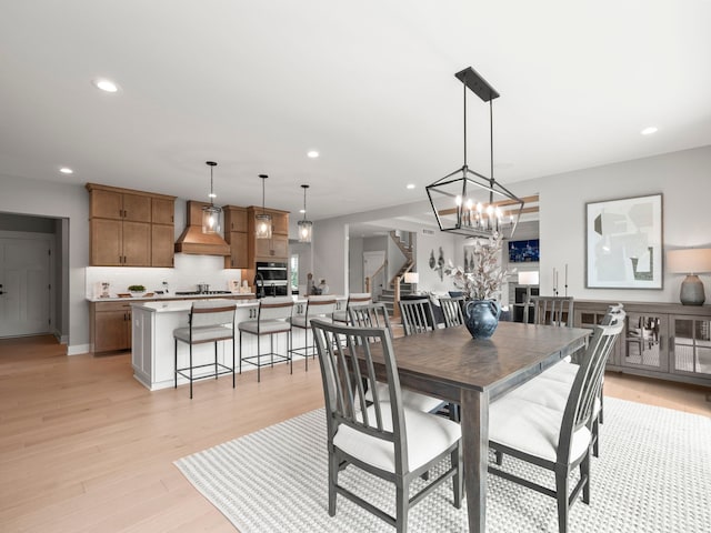 dining room featuring recessed lighting, baseboards, stairway, and light wood finished floors