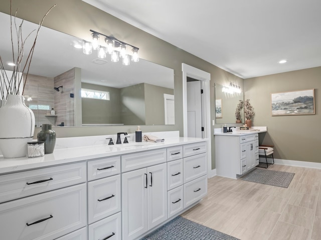 full bath with vanity, baseboards, and walk in shower