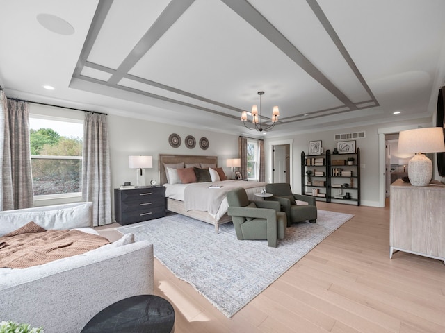 bedroom featuring a tray ceiling, a notable chandelier, light wood finished floors, visible vents, and ornamental molding