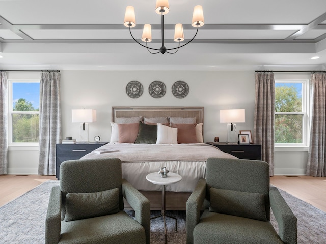 bedroom featuring baseboards, multiple windows, a chandelier, and wood finished floors