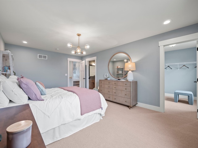 bedroom with a walk in closet, recessed lighting, visible vents, light carpet, and baseboards