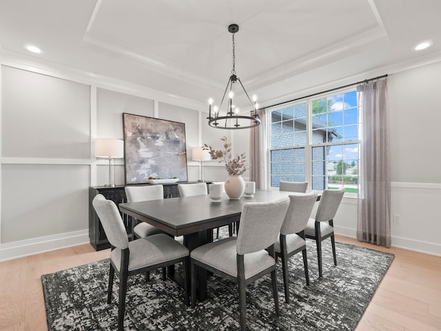 dining space with a tray ceiling, baseboards, light wood finished floors, and recessed lighting