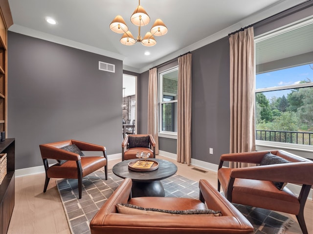 living area with an inviting chandelier, baseboards, visible vents, and ornamental molding