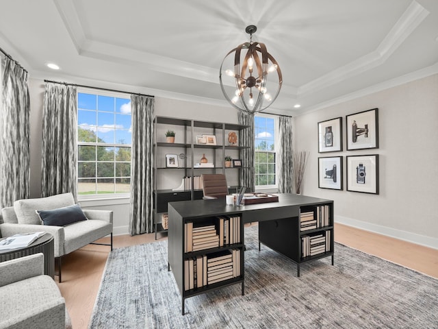 office space with a tray ceiling, an inviting chandelier, ornamental molding, wood finished floors, and baseboards