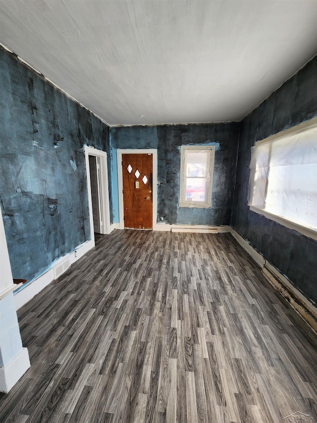 unfurnished living room featuring wood finished floors and baseboards