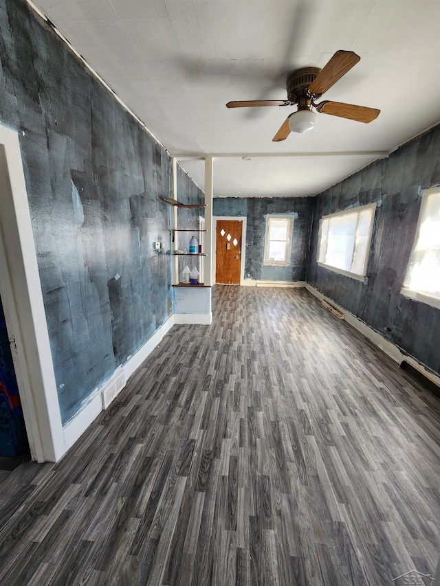 unfurnished living room with baseboards, visible vents, and wood finished floors