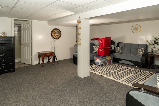 finished below grade area featuring a paneled ceiling and carpet