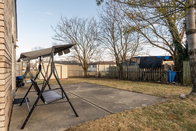 view of patio featuring a storage unit, an outdoor structure, and a fenced backyard