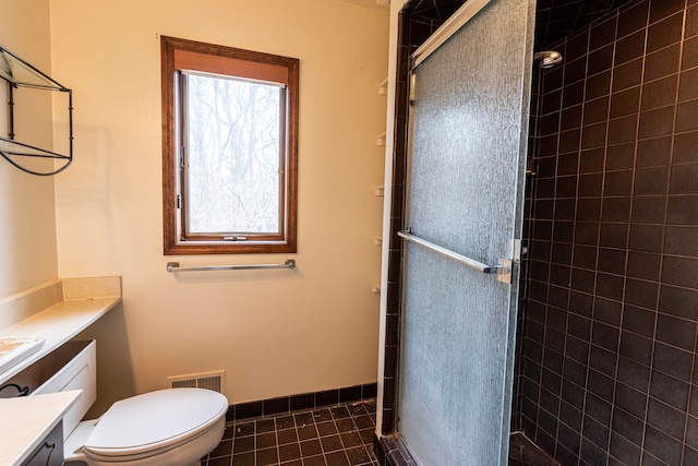 full bath with baseboards, toilet, tile patterned flooring, vanity, and a shower stall