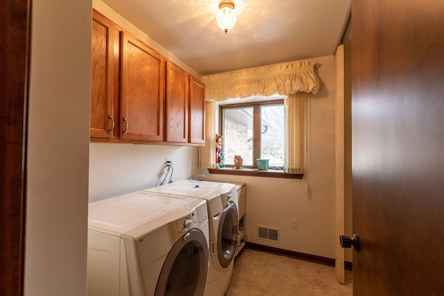 washroom with cabinet space, visible vents, baseboards, and separate washer and dryer