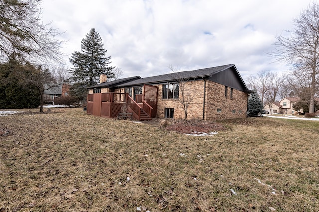 view of property exterior featuring a wooden deck, a chimney, stairs, a yard, and brick siding