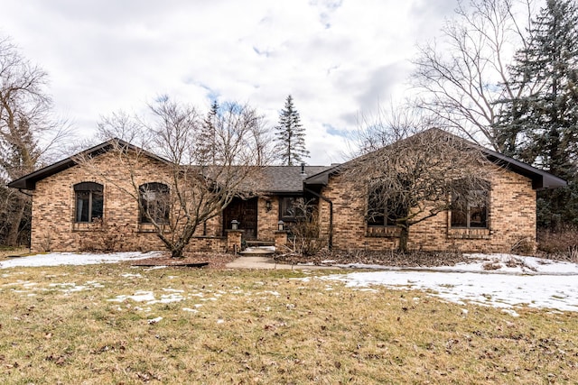 single story home featuring brick siding and a front lawn