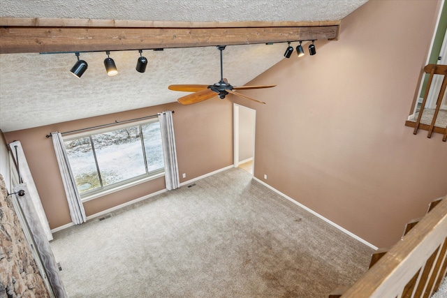 unfurnished living room with carpet, lofted ceiling, a textured ceiling, baseboards, and stairs