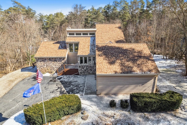 view of front of property with a shingled roof and stone siding