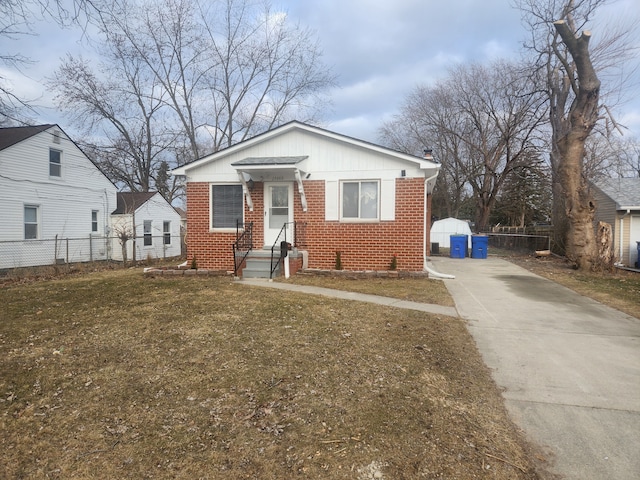 bungalow featuring concrete driveway, brick siding, and fence